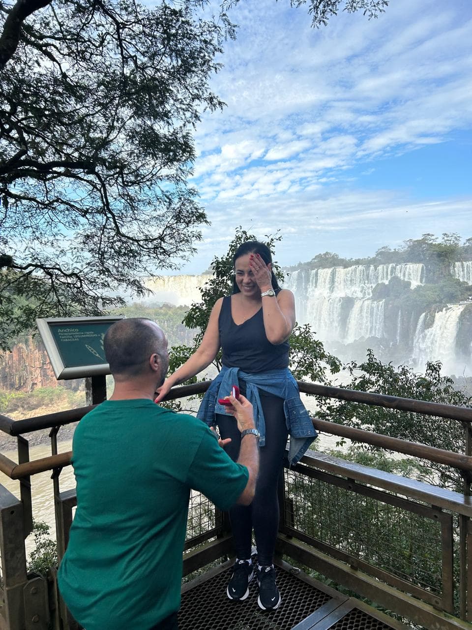 Geremias de joelhos pedindo Jaqueline em casamento, com as Cataratas do Iguaçu ao fundo